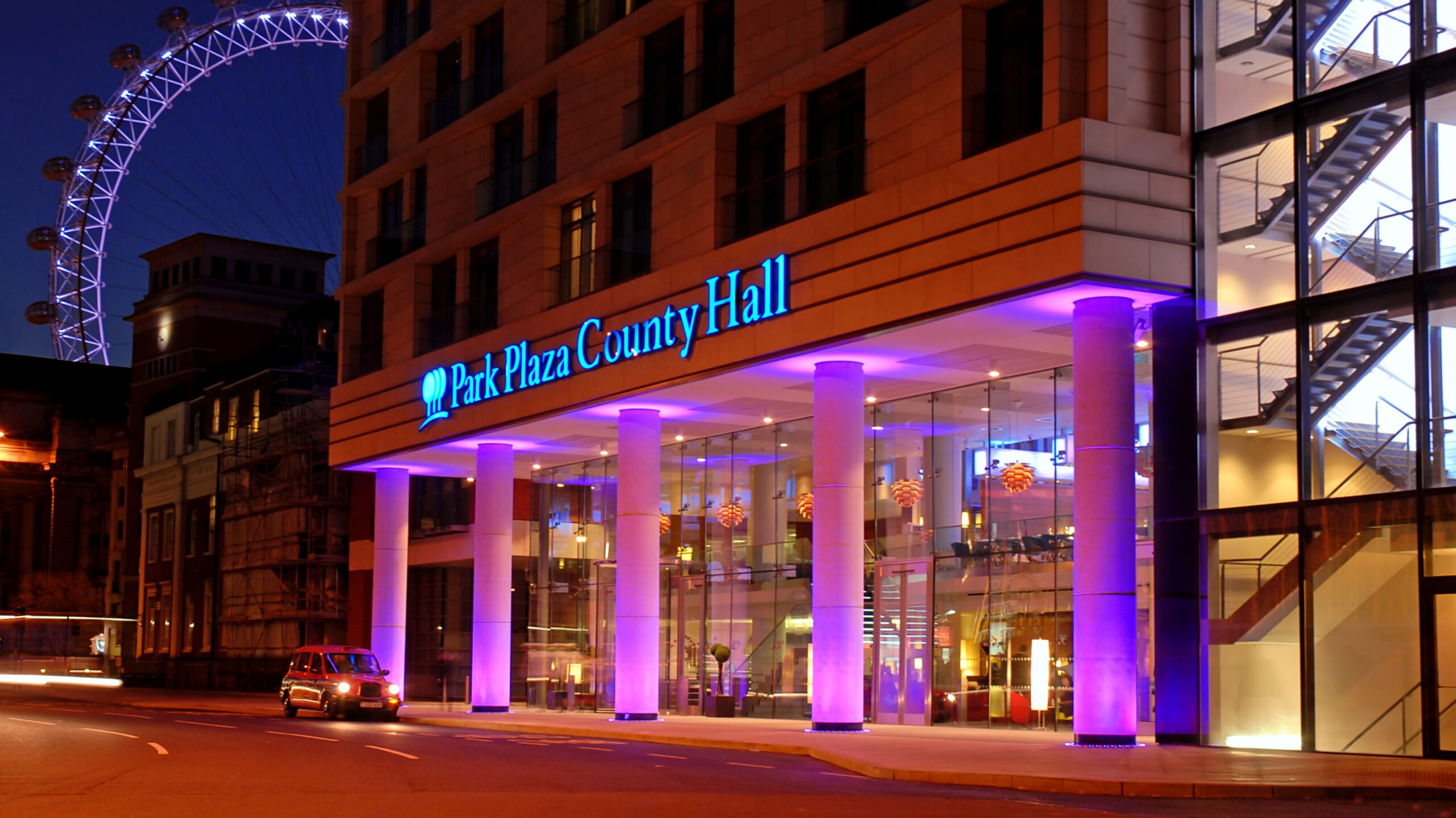 front of a hotel, lit up with purple lights